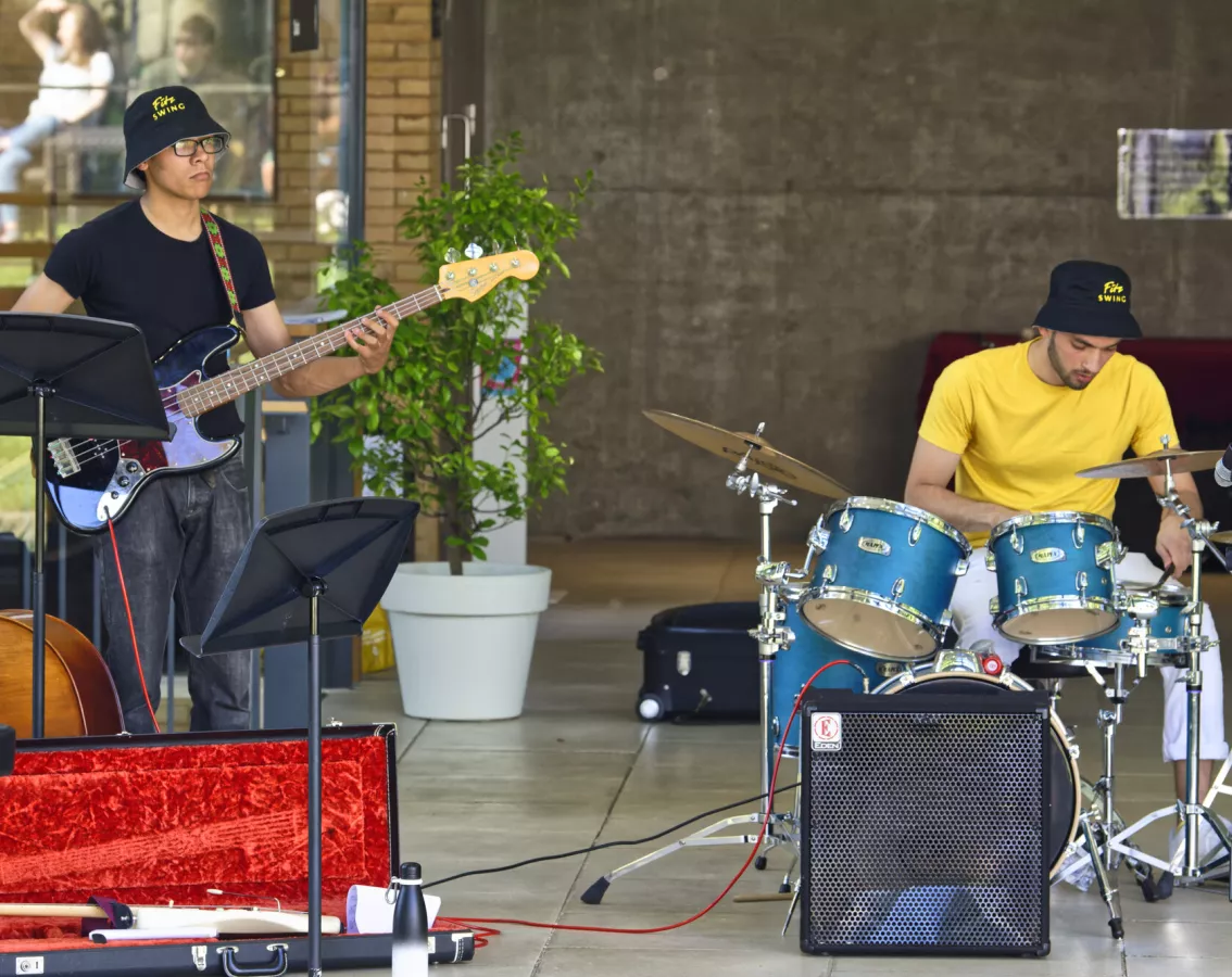 Students playing an electric guitar and drums