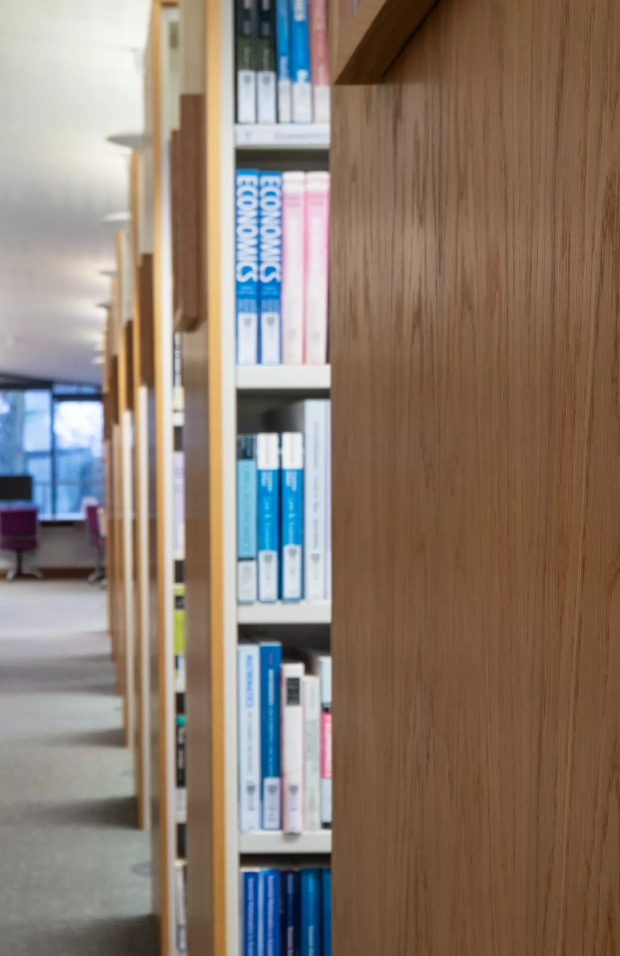 Books on a shelf and a view down the upper level corridor