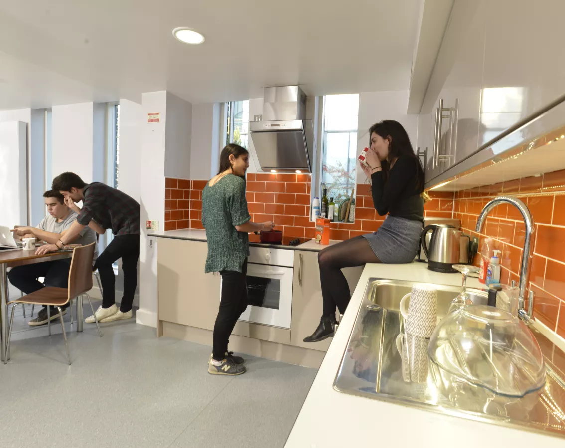 Students chatting in the large shared kitchen