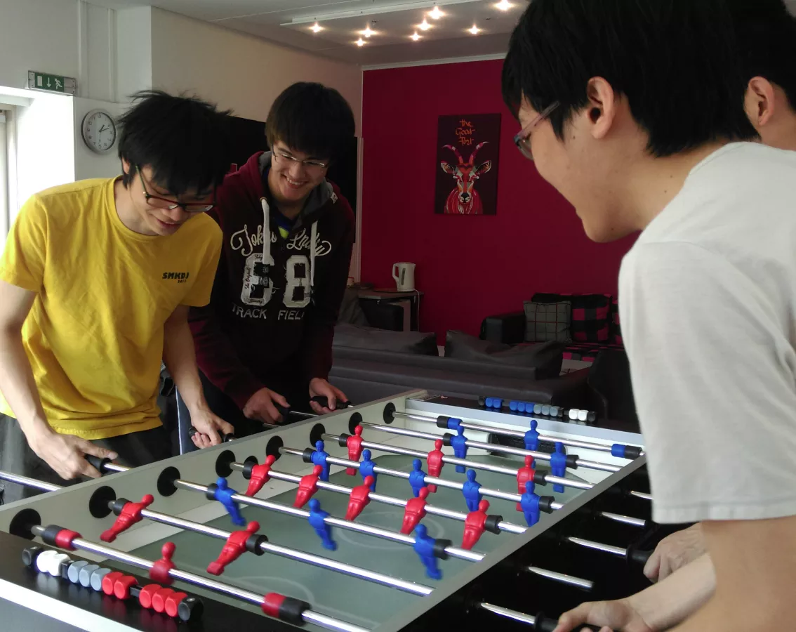 Four students are playing table football