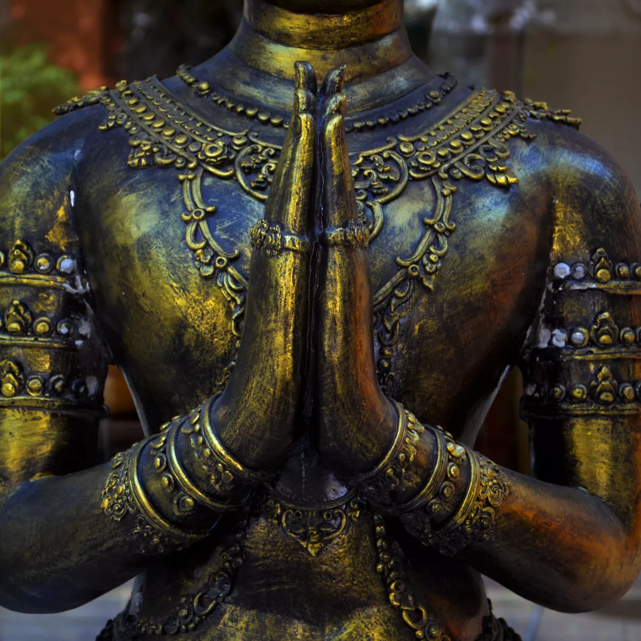 Bronze statue with hands in prayer